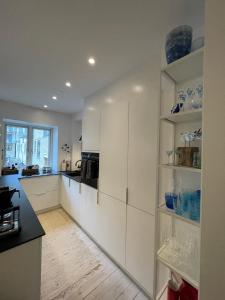 a kitchen with white cabinets and a counter top at CanalLiving-CPH in Copenhagen