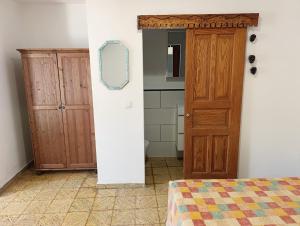 1 dormitorio con puerta de madera y espejo en Casa Dace Renovated Studio - Fast Wi-Fi, 4-min Drive to Beach, Pet Friendly, en San Nicolás