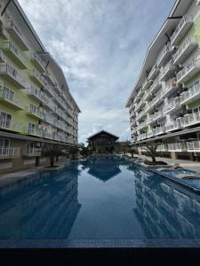 a swimming pool in the middle of two apartment buildings at JNest Cozy Condo Bldg A 215 in Lapu Lapu City