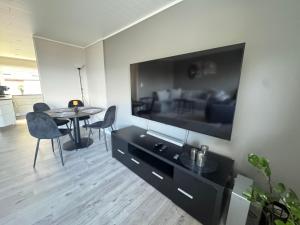 un salon avec une grande télévision et une table dans l'établissement Ålesund sentrum apartment, à Ålesund