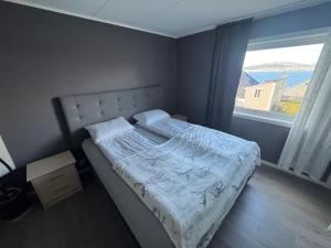 un lit dans une chambre avec une grande fenêtre dans l'établissement Ålesund sentrum apartment, à Ålesund