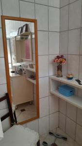 a bathroom with a mirror and a sink with flowers at Casa Vintage in Joinville