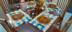a glass table with plates and wine glasses on it at Casa Vintage in Joinville +20 photos