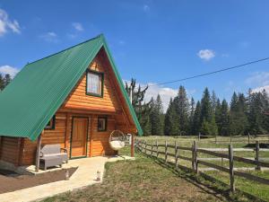 a log cabin with a green roof at Old Story Chalets in Žabljak