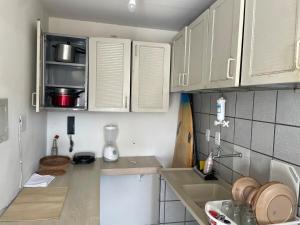 a small kitchen with white cabinets and a sink at Apartamento aconchegante in João Pessoa