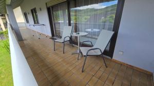 balcone con 4 sedie e tavolo. di Ferienwohnung Pele a Freudenberg am Main