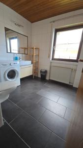 un bagno con lavandino e lavatrice di Ferienwohnung Pele a Freudenberg am Main