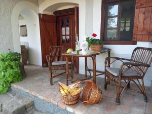 a patio with a table and chairs and a table with bananas at Műemlék parasztház in Szentbékkálla