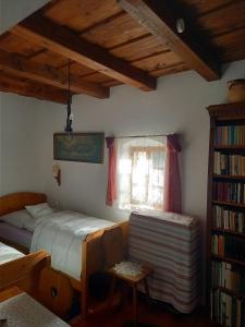 a bedroom with a bed and a book shelf at Műemlék parasztház in Szentbékkálla