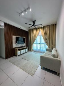 a living room with a couch and a flat screen tv at NeoSkyhigh Suites in Batu Kawan