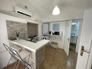 una cucina con un bancone e sedie in una stanza di Blue Iris Home Sanremo a Sanremo