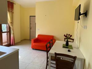 a living room with a table and a red couch at Dal Barone in Capo Vaticano