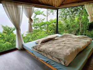 a bed in a room with a large window at Cloud Garden in Bắc Yên