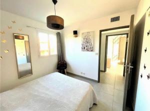 a bedroom with a white bed and a mirror at un gout de paradis in Zonza