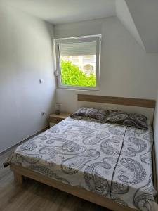 une chambre avec un lit et une fenêtre dans l'établissement Apartmani Jadranka, à Vodice