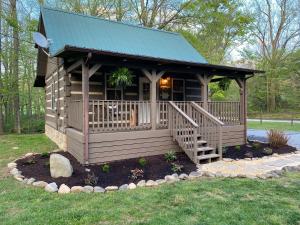 a small cabin with a porch and a green roof at Home Sweet Home on Cosby Creek in Cosby