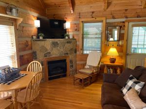 a living room with a couch and a fireplace at Home Sweet Home on Cosby Creek in Cosby