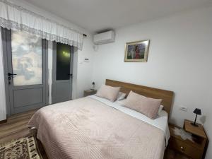 um quarto com uma cama grande e uma janela em Double17 Apartaments em Gjirokastër
