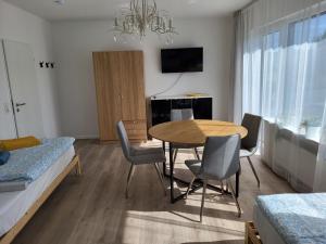 ein Zimmer mit Tisch und Stühlen und ein Schlafzimmer in der Unterkunft Emily Apartments, moderne ruhige Wohnung, nur 4 km von der A2 in Leopoldshöhe