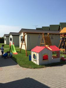 a playground with a play set and a slide at Ośrodek Niebiańska Plaża in Sarbinowo