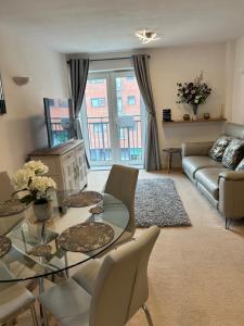 a living room with a glass table and a couch at City Centre apartment. in Wrexham