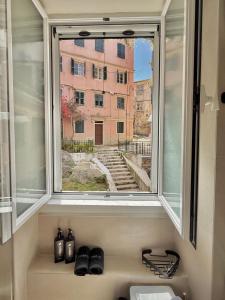 a window with a view of a building at Lumière Carmela in Corfu