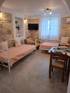 a living room with two beds and a table at Patriko Stone House in Fourka