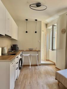 a kitchen with white cabinets and a table in it at Lumière Carmela in Corfu