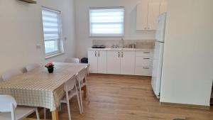 a kitchen with a table and a white refrigerator at רגעים בגולן in Keshet