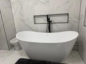 リバプールにあるStylish city centre Penthouseのトイレ付きの浴室にある白い浴槽 +33枚の写真