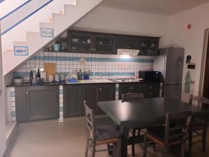 a kitchen with a table and chairs and a staircase at Casa Luca ai Borghi di Villasimius in Villasimius
