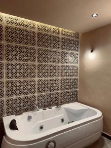 a white bath tub in a bathroom with a tile wall at Big Apartment in Central Medina 3BR ,view and Jacuzzi Tetouan in Tetouan +16 photos