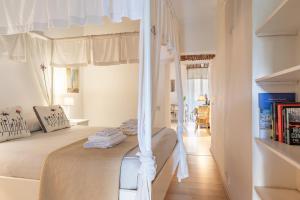 Un dormitorio con una cama con dosel y cortinas blancas. en Julie - Casa del '700, en Castel Gandolfo