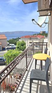a balcony with a yellow table and chairs and a view at Guesthouse Martina in Senj