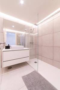 a white bathroom with a sink and a mirror at Lusíadas 53 1ºE in Lisbon +7 photos