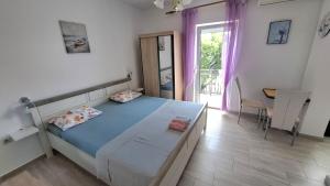 a bedroom with a bed and a table and a window at Guesthouse Martina in Senj