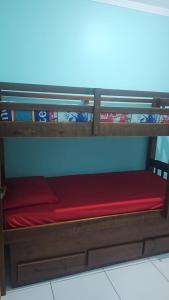 un lit superposé avec un matelas rouge dessus dans l'établissement Casa na Praia Grande, à Praia Grande 6 autres photos