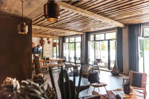 a large room with tables and chairs and windows at Ammersee-Hotel in Herrsching am Ammersee