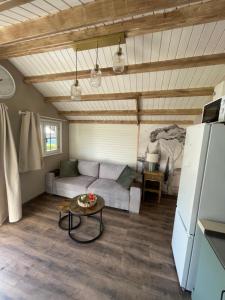 a living room with a couch and a table at Le petit chalet in Brêmes