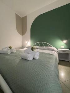 een slaapkamer met een groot bed met handdoeken erop bij B&B La Palma in Petacciato