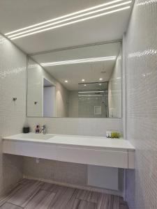 a bathroom with a sink and a large mirror at City Centre Studio Apartments Nicosia in Nicosia