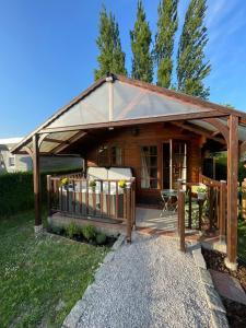 a wooden cabin with a porch and a deck at Le petit chalet in Brêmes