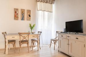 comedor con mesa y TV en un escritorio en Julie - Casa del '700, en Castel Gandolfo