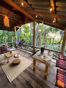 a porch of a house with tables and a swing at Unity coliving in Thong Sala +35 photos