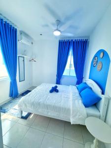 una camera da letto con tende blu e un letto con una sedia blu di Santorini Vibes Penang - Tasek Gelugor a Kampong Selamat