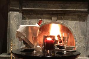 a table with a candle and glasses in front of a fireplace at Berbère Palace in Ouarzazate