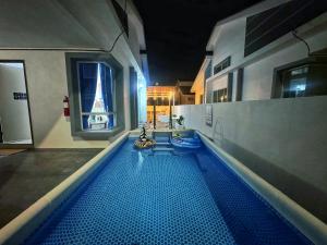 una piscina in un edificio di notte di Santorini Vibes Penang - Tasek Gelugor a Kampong Selamat