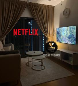 a living room with a tv and a table in front of a window at D'Myras Homestay Splash Mania, Gamuda Cove in Banting