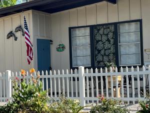 a white fence in front of a house with a flag at Beautiful Beach Oasis - 5 Blocks from the Beach in Jacksonville Beach