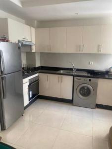 阿加迪尔Adan Beach Apartment的厨房配有冰箱和洗衣机。